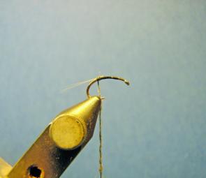 Place the hook in the vice and attach the thread, wind to the bend of the hook and tie in 4 grey micro fibbets. Then apply a small amount of dubbing to the thread