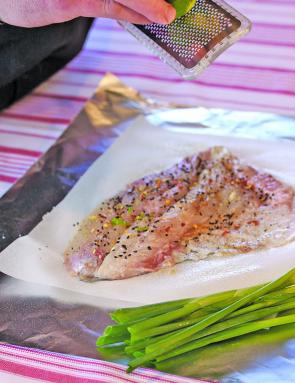 Season the dory fillet on the grease paper and foil.