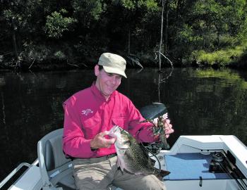 The author smiling fondly at a stonker Somerset bass in one hand and a regular sized redclaw in the other.