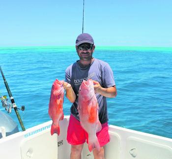 Theo displaying a couple of sought after coral trout, caught at the Great Barrier Reef.