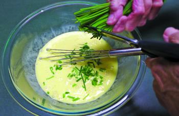 Blend the grated garlic into the cream and egg mixture. Snip the chives into the mixture. Whisk the chives in.