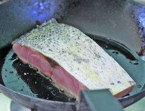 Sealing the fish in the hot pan.