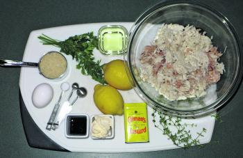 The ingredients for the crab cakes: crab meat, fresh thyme, dry mustard, mayonnaise, Worcestershire sauce, salt, egg, dried breadcrumbs, fresh parsley, canola oil for sautéing, lemon.