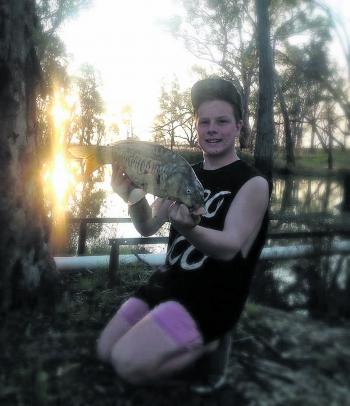 Kaleb Oxley with a rare mirror carp caught in a local creek.