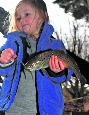 Kids don’t mind the cold weather if it means catching a few fish. Lilah Kent displays a healthy little brown trout taken from the Ford River.