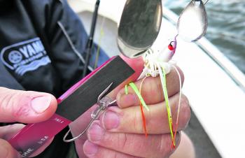 A fine file or sharpening stone is perfect for touching-up dulled hook points. Here the author is re-sharpening the hooks on a spinnerbait after they lost their sticky edge due to repeated contact with submerged rocks.