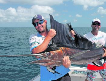 The author helping Renegade client Glenn with his first-ever sailfish.