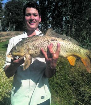 Pete Vandermeer with a carp caught on bait while fishing the backwaters of a high Goulburn River.