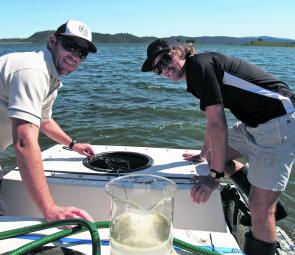 DPI Fisheries Luke Cheviot and Brendan Findlay get busy stocking the dam with bass.