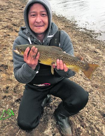 Tom Nyugen with his PB brown trout from Newlyn Reservoir casting a rainbow pattern Bullet Lure.