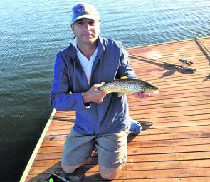 Shane Stevens with a 1.5lb brown trout caught on a mudeye suspended under a bubble float from one of Lake Wendouree’s many jetties. Photo courtesy Barry Whelan.