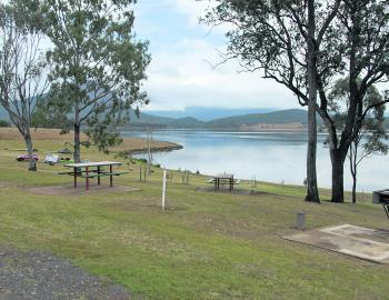What’s not to like about this scenario – handy picnic tables and a wood-fired BBQ with ample camping areas right by the lake.