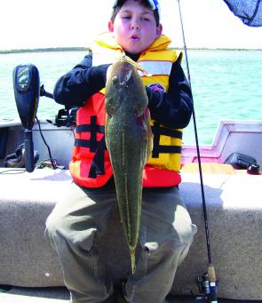 Zach Wright can barely hold up this horse of a flathead that he caught on a soft plastic. It nudged 70cm.