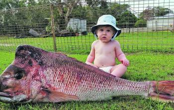 Ari Carter behind a 22lb snapper caught by his dad.