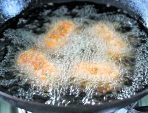 Make the croquettes and drop them into hot oil, four at a time.