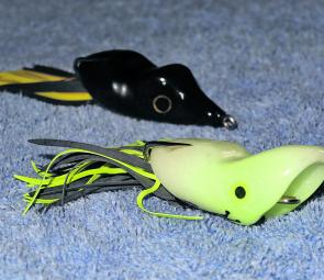 Different colours and different styles. A Glo Scum Frog Popper (cup-faced) and a Black Bass Rat with its pointed nose. Aussies like black for after dark surface work, most other countries opt for whites and glows.