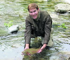 The fat rainbow trout held by the author is typical of those in many New England streams at the present time. 