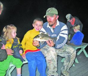 Young Harley’s first fish: The author holds the bass, which took a surface lure. 