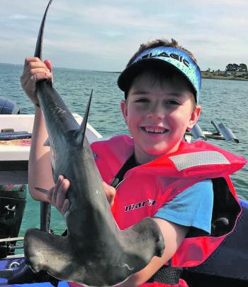 Young Taj Catterson with a nice hammerhead shark caught recently off Elizabeth Island. Photo courtesy of Matt Catterson.