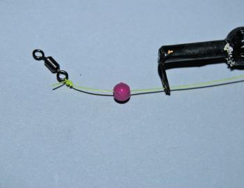 Once passed through the bottom eyelet, place a small bead on the line and then attach a small swivel with a blood knot (or similar). The bead stops the knot of the swivel jamming on the eyelet of the float, which would restrict the bait from sinking down 