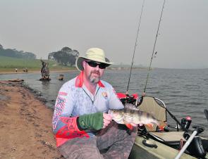 With the haze of summer bushfires all around, the author shows off one of the better reddies caught that morning.