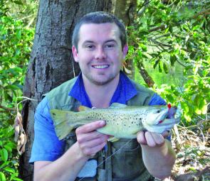 The author shows off a 1.1kg brown trout caught in the Tarago River on a Squidgy Shad in redfin pattern.
