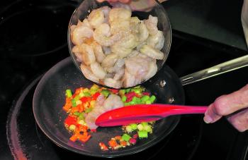 Add the prawns to the pan and cook until the prawns are pink and cooked through.