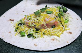 Lay the tortillas out on a clean work surface. Sprinkle half of the cheese mixture over half of each tortilla, leaving a clean border around the edge of the tortilla. Lay a quarter of the prawn mixture over the top of the cheese. Now sprinkle some of the 