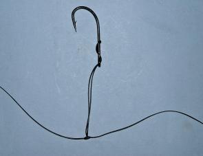 Twist the loop around and then pass it back over the hook again so that it is criss-crossed over the hook shank as shown. Pull this up tight. 