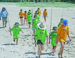 The kids marched across the sand to receive their bait.