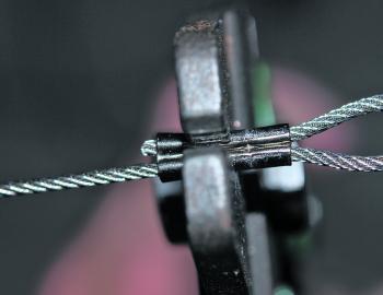 For heavy multi-strand wire, use a brass or copper crimp. With figure-of-8 crimps, each side of the crimp constricts individually around each strand of wire and ends up being virtually round. The crimp goes into the plier sideways. Start from one end (no 