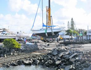 One of the last remaining boats is craned off the hardstand at the Coffs Harbour slipway.